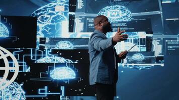 African american male specialist presenting deep learning AI systems, ensuring robotics for automation and neural networks brain innovation. Young professional presenter host. Camera A. video