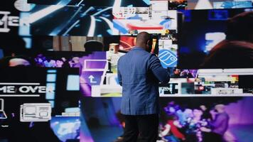 African american digital creator interacting with high tech visuals and screens, illustrating cloud based systems, e commerce trends and big data in web networking tech environment. Camera A. video