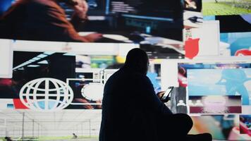 Black man holding a device portraying the harmful effects of excessive social media interaction, social anxiety and isolation in the digital world. Showcases manipulation and paranoia. Camera A. video
