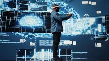 ung afrikansk amerikan ingenjör fokuserade på vr headsetet programmering och analys, omgiven förbi neuralt nät system och ai data visualisering. innovation och cybernetik. kamera a. video