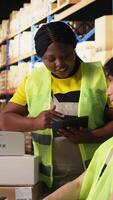 Vertical Satisfied coworkers sharing a high five after successful order processing, feeling proud of their teamwork in the industrial retail facility. Fulfillment center employees in workwear. Camera A. video