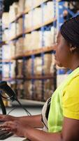 Vertical Staff member managing barcodes awb scanning tasks for online shopping orders, merchandise with shipping labels and details for easy delivery. Fulfillment center employee. Camera A. video