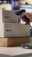 Vertical Male depot worker scanning barcodes on packages in a warehouse, registering shipment details and tracking numbers on tags. Fulfillment center logistics to provide parcel status. Camera A. video