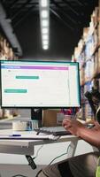 Vertical Female warehouse clerk registering barcodes for packages, scanning the shipping labels and awb tags on cardboard boxes. Fulfillment center distribution operations for e-commerce. Camera A. video