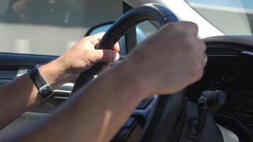 Hands gripping the steering wheel while driving on a highway, with visible interior details and a road view in background video