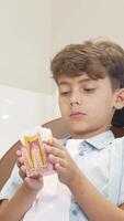 Joyful young boy beams while proudly holding a colorful tooth model video