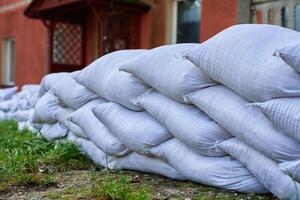 Sandbags stacked near house to protect from flood risk emergency photo