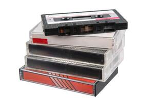 Retro magnetic tape cassette on top of a pile of plastic cases, isolated on white background. photo