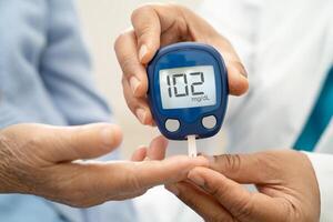 Doctor check diabetes from finger blood sugar level finger lancet. photo
