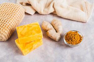 Herbal turmeric soap bars and root on the table photo