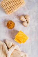 Herbal turmeric soap bars and root on the table top and vertical view photo