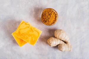 Close up of homemade natural turmeric soap and ingredients on the table top view photo