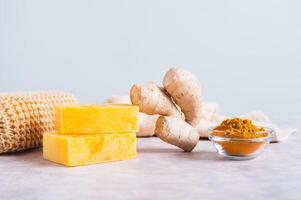 Homemade natural turmeric soap and ingredients on the table photo