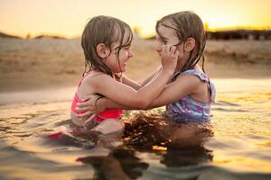 Sisters play at the beach at sunset, making memories photo