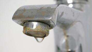 Water is dripping from damaged faucet. The old faucet was covered with lime scale due to poor water quality and hard water. Useless use of water. Plumbing problems. 4k video