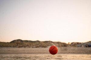 Family enjoys a day of basketball fun at the beach during sunset photo