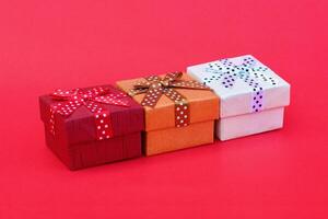 three gift boxes on red background photo