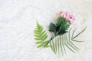 bouquet of flower with leaves on white artificial wool background photo