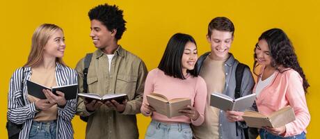 Students study in library, young people spend time together and search information. Happy generation z multiracial student read books and talk in college, isolated on orange background, studio shot photo