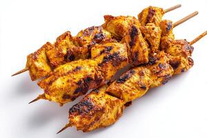 High quality photo of curry marinated grilled chicken skewers on white background