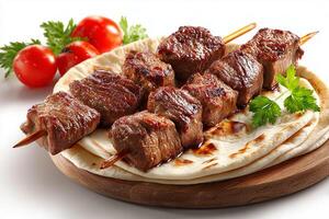 Grilled beef kababs served on soft flatbread on white surface photo