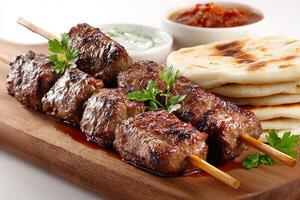 Tasty beef kababs with flatbread and dip on clean white surface photo