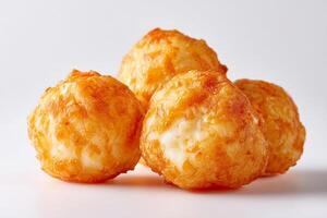 Crispy golden cheese balls deep fried and ready to eat on white background close up photo