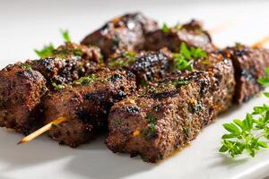 Delicious grilled beef kababs with cumin flavor arranged on white surface close up photo