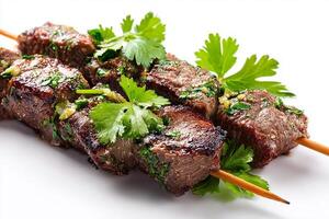 Juicy grilled beef skewers topped with fresh green coriander leaves photo