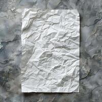 Crumpled White Paper Sheet on Gray Textured Surface in Studio Setting photo