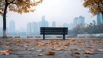 Empty Park Bench in Autumn Scene with Fallen Leaves and City Skyline in the Background photo