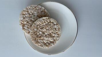 Crispy rice cakes on a white plate, minimalistic healthy snack concept. Perfect for diet, nutrition, and clean eating themes, this image is ideal for food blogs, wellness articles, and healthy lifestyle promotions. High-resolution, isolated on a bright ba photo