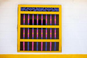 Beautiful facades of the colonial houses at the streets of the Heritage Town of Jerico located in the Department of Antioquia in Colombia. Yellow, pink and purple. photo