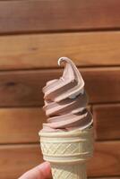 Vanilla and chocolate soft ice cream in the wooden background. Ice cream mix. photo