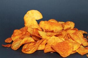 Chips with paprika on a dark background. photo