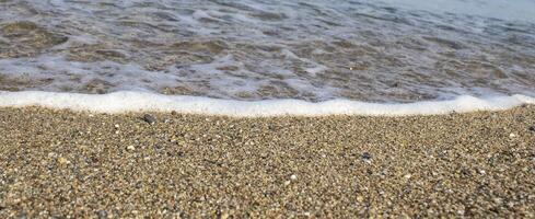 Close-up of Pebble Beach with Light Reflecting on Stones. Pebble Beach and Sea Waves photo