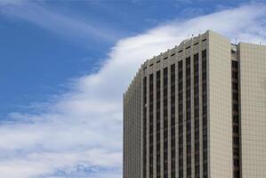 View of a Modern Office Building Against the Background of the Sky Extending Towards the Clouds photo