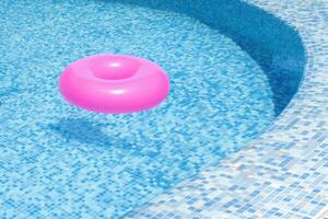 Pink Inflatable Ring Floating at Swimming pool. Swimming Pool in Summer photo