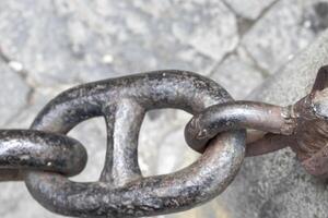 Close-up of an Old Rusty Chain Isolated. Large Chain Links on a Gray Background. The Concept of Bondage and Restriction of Freedom. Slavery. Free Space for Text photo