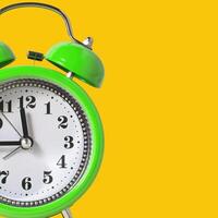 Retro Alarm Clock. Close up One Classic Alarm Clock on a Yellow Background photo