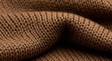 Close-up of the texture of brown knitted fabric, showcasing its intricate weave and soft, cozy appearance. photo