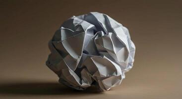 A simple ball of crumpled paper, showcasing texture and imperfection, symbolizing a discarded idea or a moment of creativity. photo