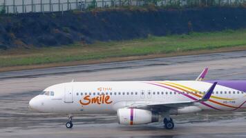 PHUKET, THAILAND - FEBRUARY 03, 2023. Airbus A320-232, HS-TXN of Thai Smile taxiing at Phuket airport, side view, medium shot. Airfield, airplane on taxiway or runway video