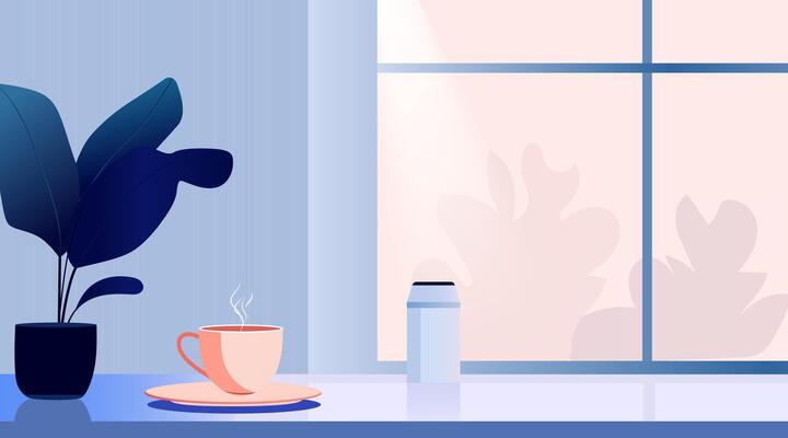 A coffee cup and plant on a table near a window
