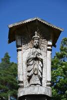 a wooden statue of a jesus figure on top of a wooden structure photo