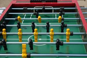 Foosball table game with player figures, handles, spinning rods. Foosball table game match players soccer ball. photo