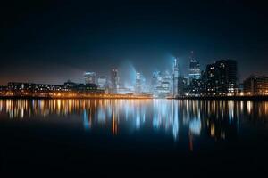 City Skyline Illuminated by Lights at Night With River Reflection and Tall Buildings photo