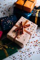 Colorful Gift Boxes With Festive Decorations and Confetti Scattered on a White Surface photo
