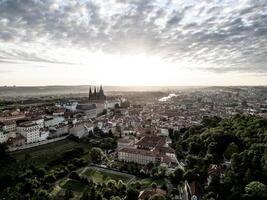 Soft morning light bathes Prague Castle and the surrounding cityscape in golden hues. Serenity fills the air as day breaks over this historic landmark, inviting exploration. photo