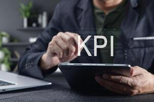 Businessman Analyzing Key Performance Indicators on Tablet Device photo